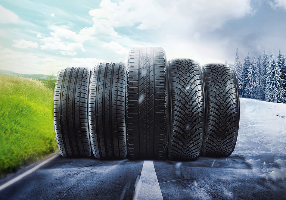 Fünf verschiedene Reifenprofile nebeneinander auf geteiltem Sommer-Winter-Straßenhintergrund